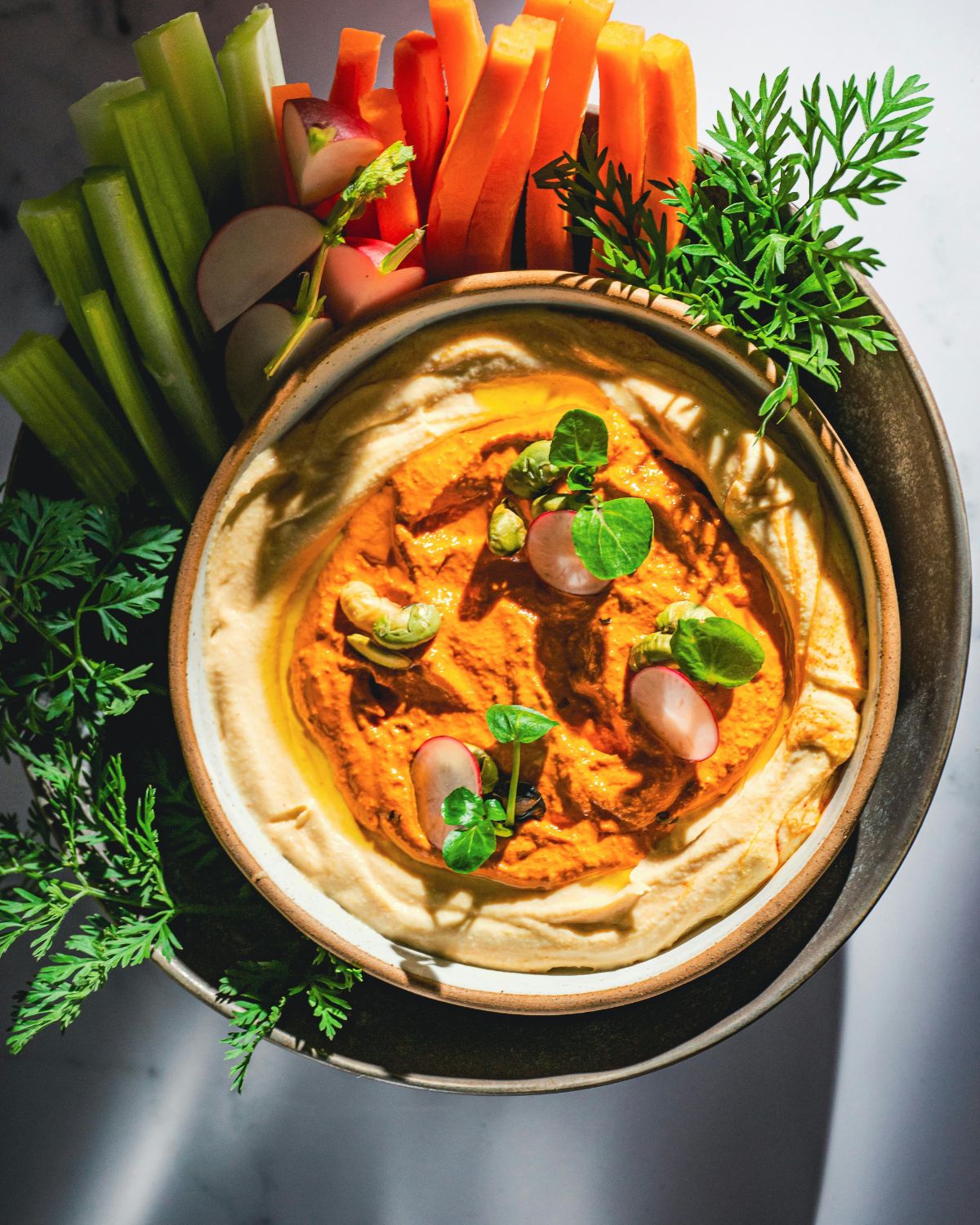 bowl of hummus with celery sticks and carrot sticks for a Quick Simple Healthy Snacks 