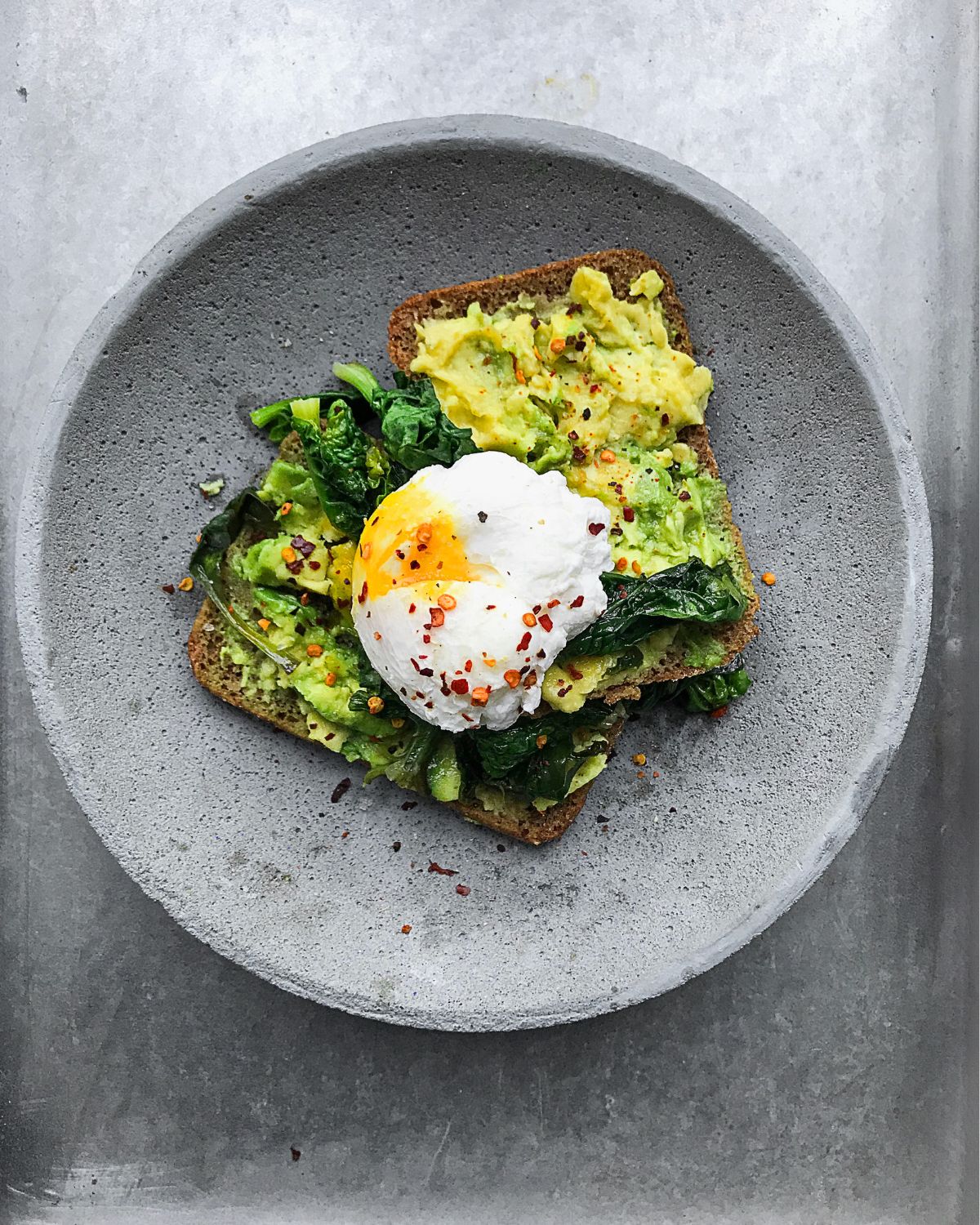 toast with avocado, spinach and egg on top 