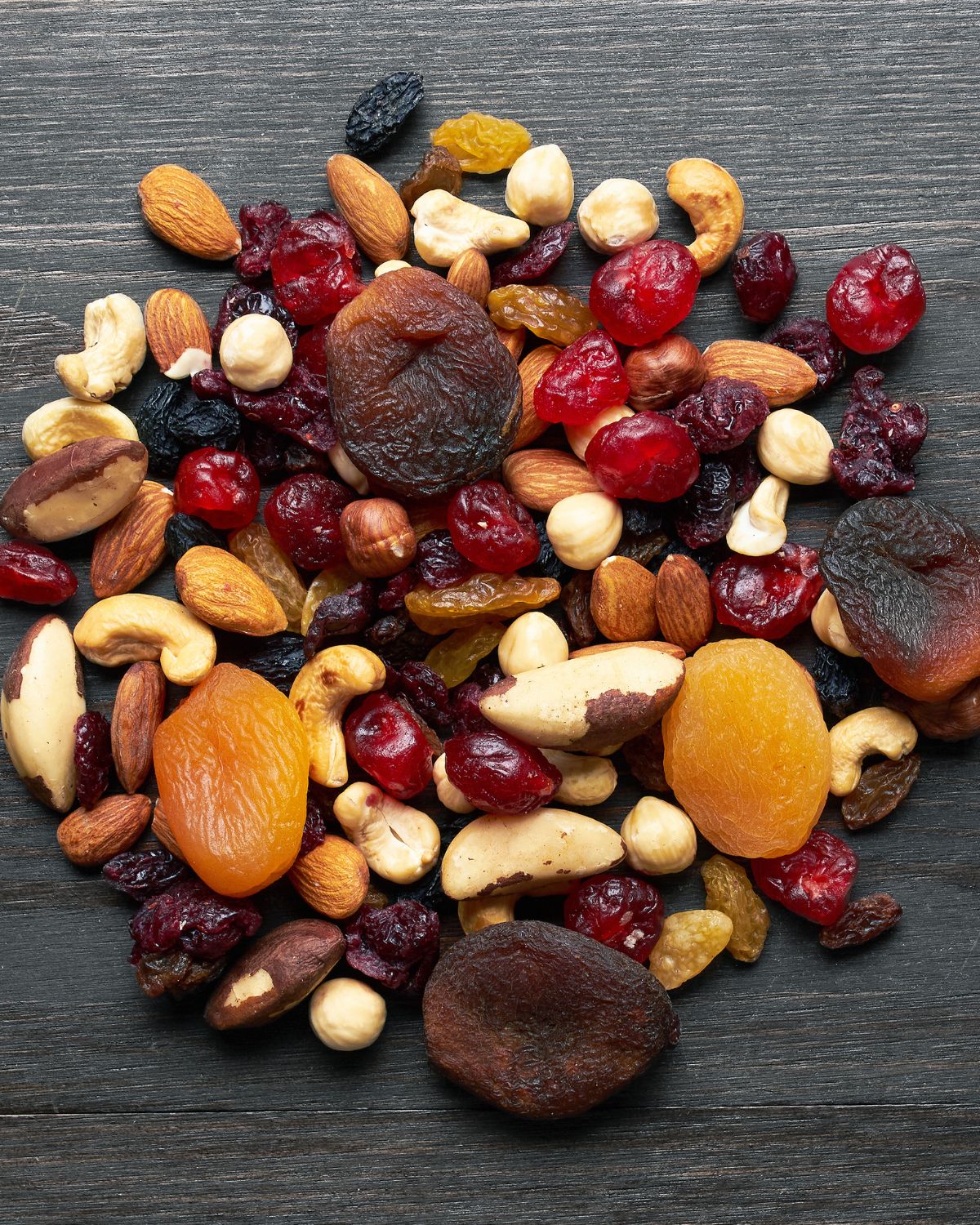 handful of nuts and dried fruit laid out on table- healthy fats source 