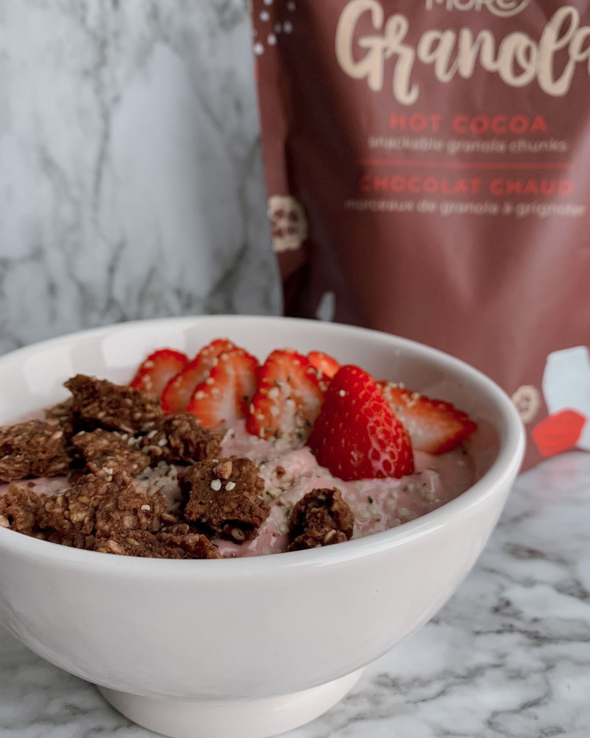 yogurt bowl topped with strawberries and granola