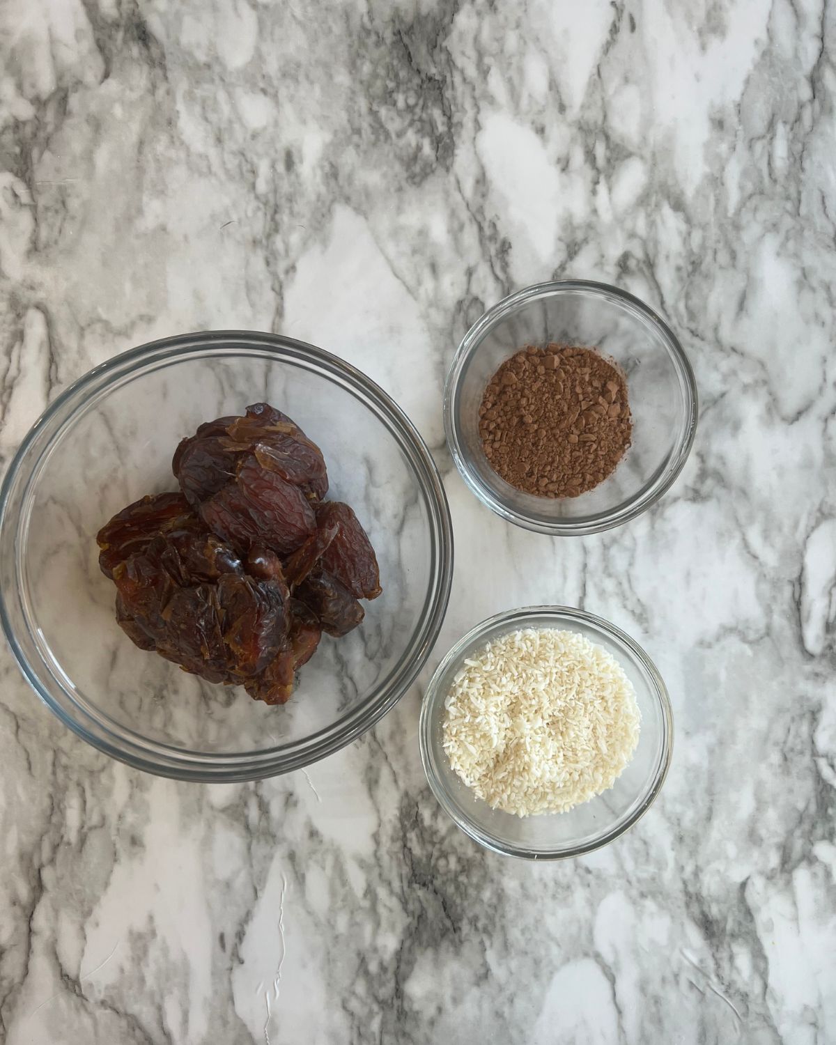 dates, cocoa powder and coconut flakes on table 