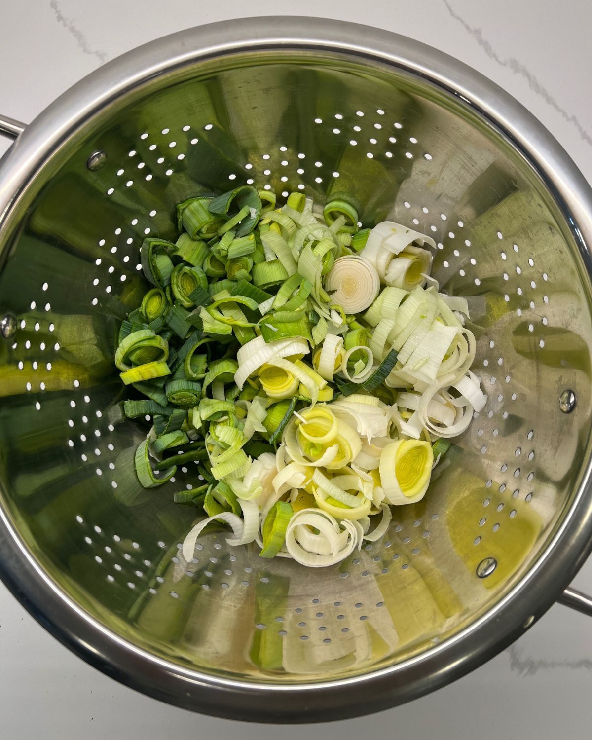 Chopping leeks in strainer ready to be washed. 