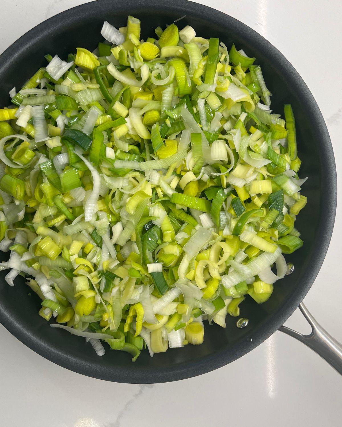 frying pan with chopped leeks in it 