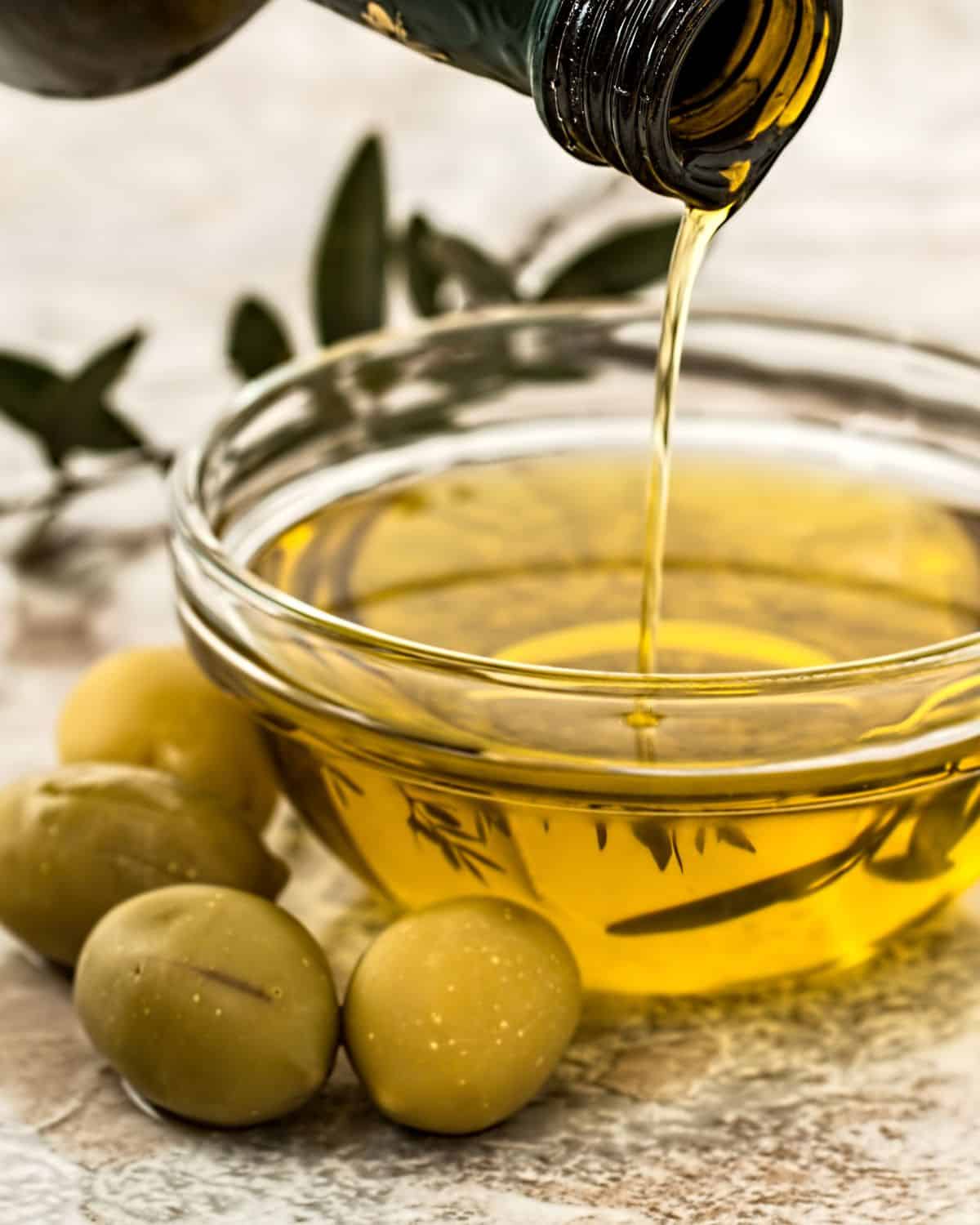 close up shot of small bowl pouring olive oil into bowl 