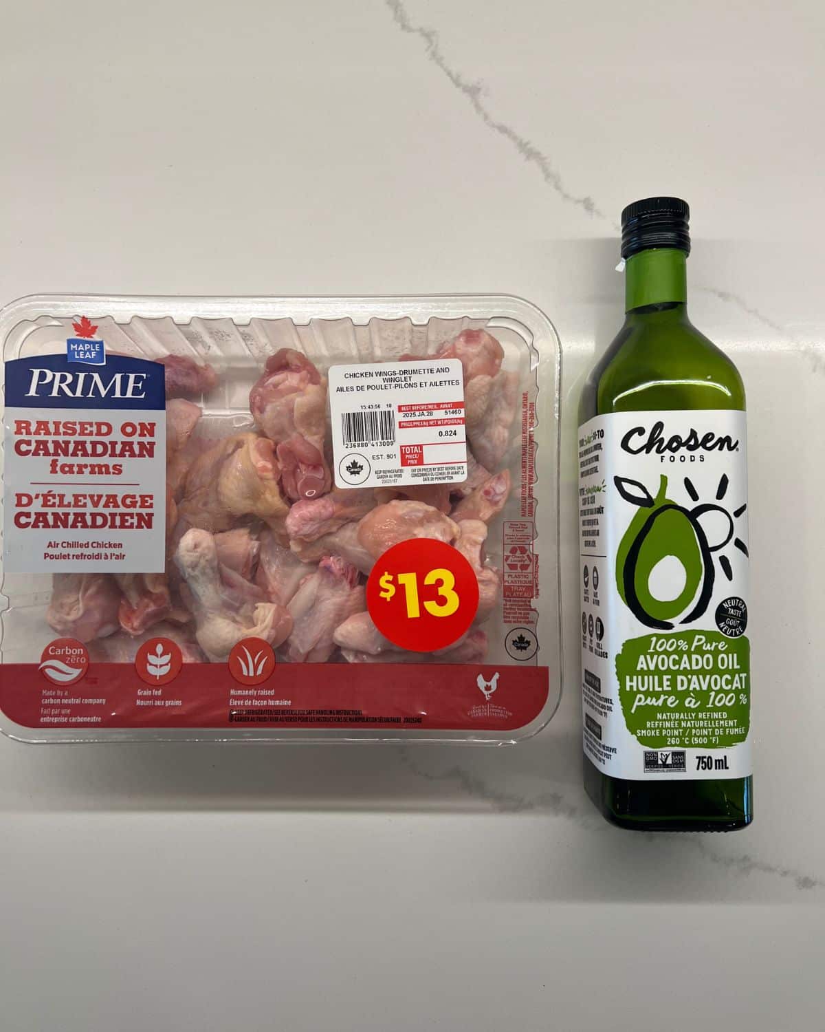 chicken wings in package with avocado oil bottle beside 