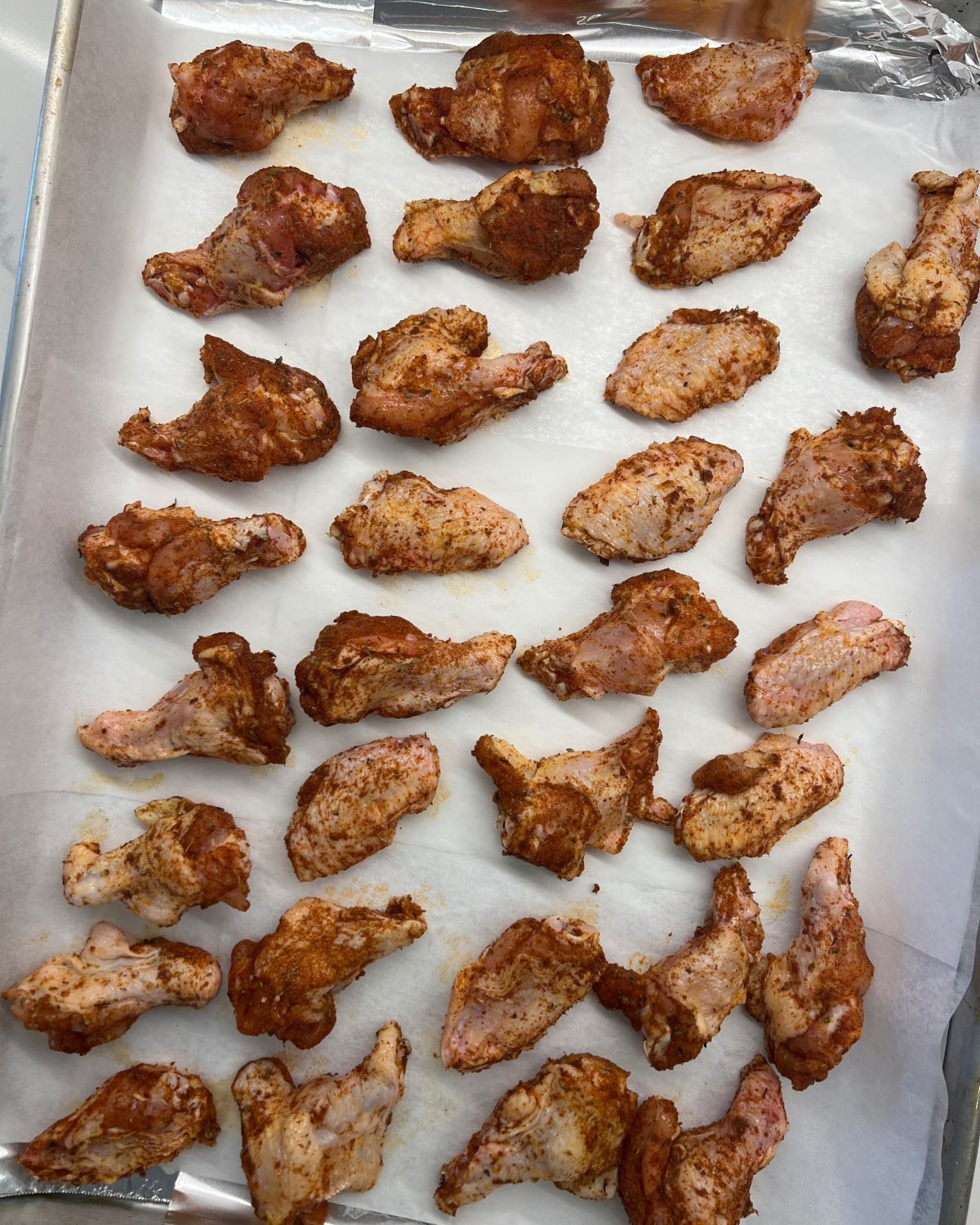 tray of chicken wings seasoned ready for oven 