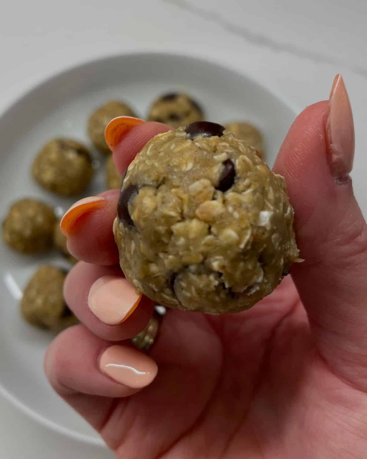 holding up a oatmeal protein ball 