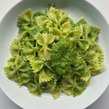 white bowl with the bow tie green sauce pasta