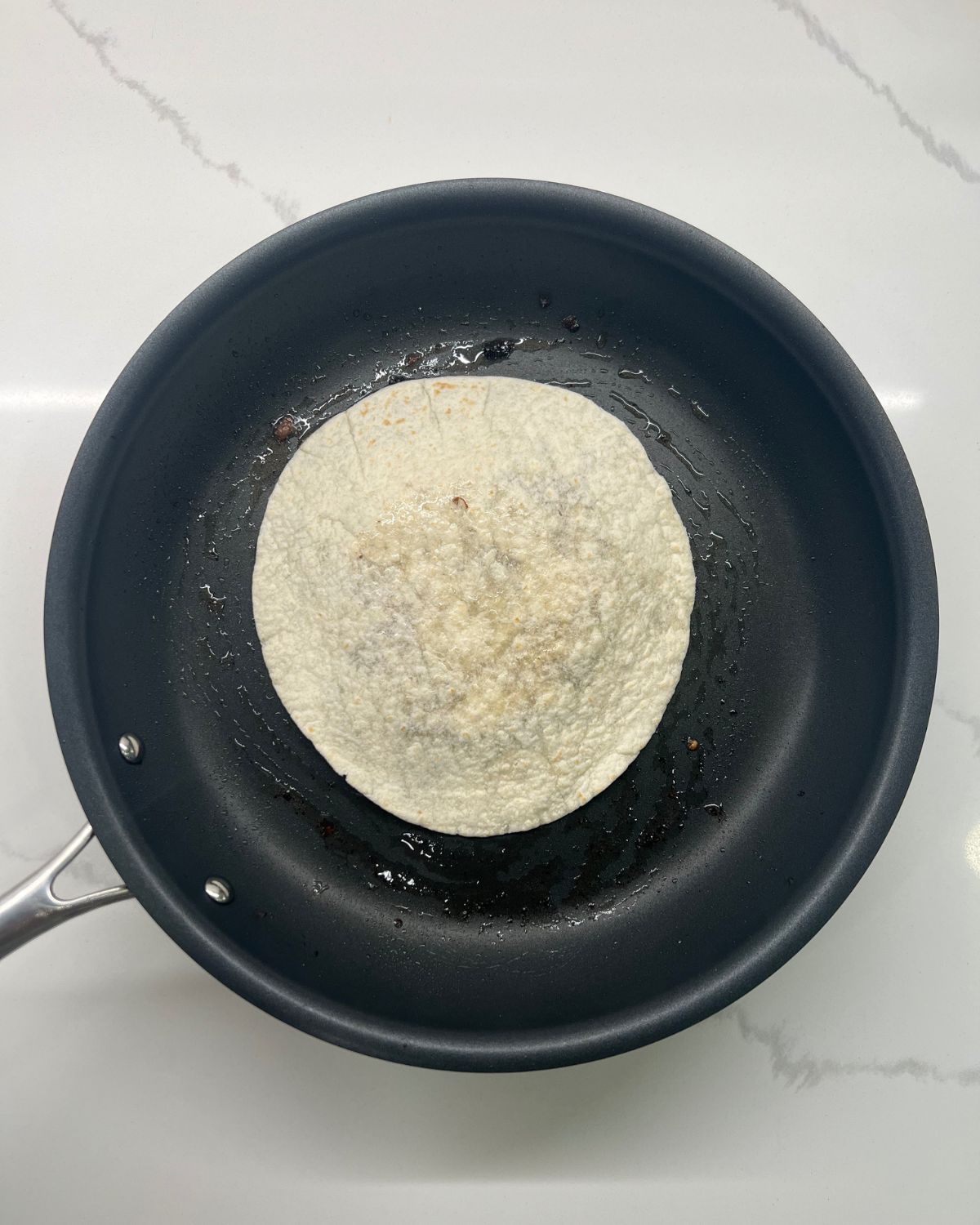 tortilla meat facing down on frying pan