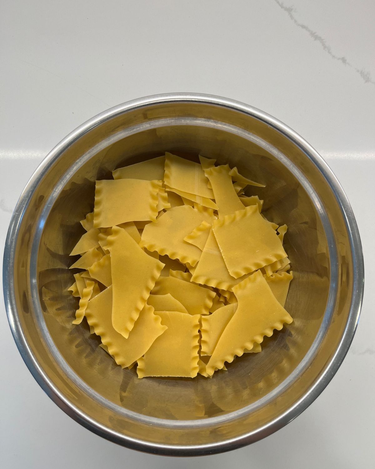 chopped up lasagna noodles in bowl 