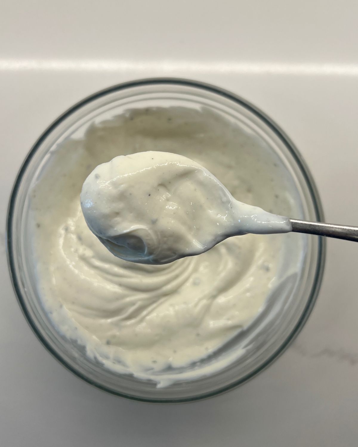 ranch dip in bowl with spoon scooping some up to camera 