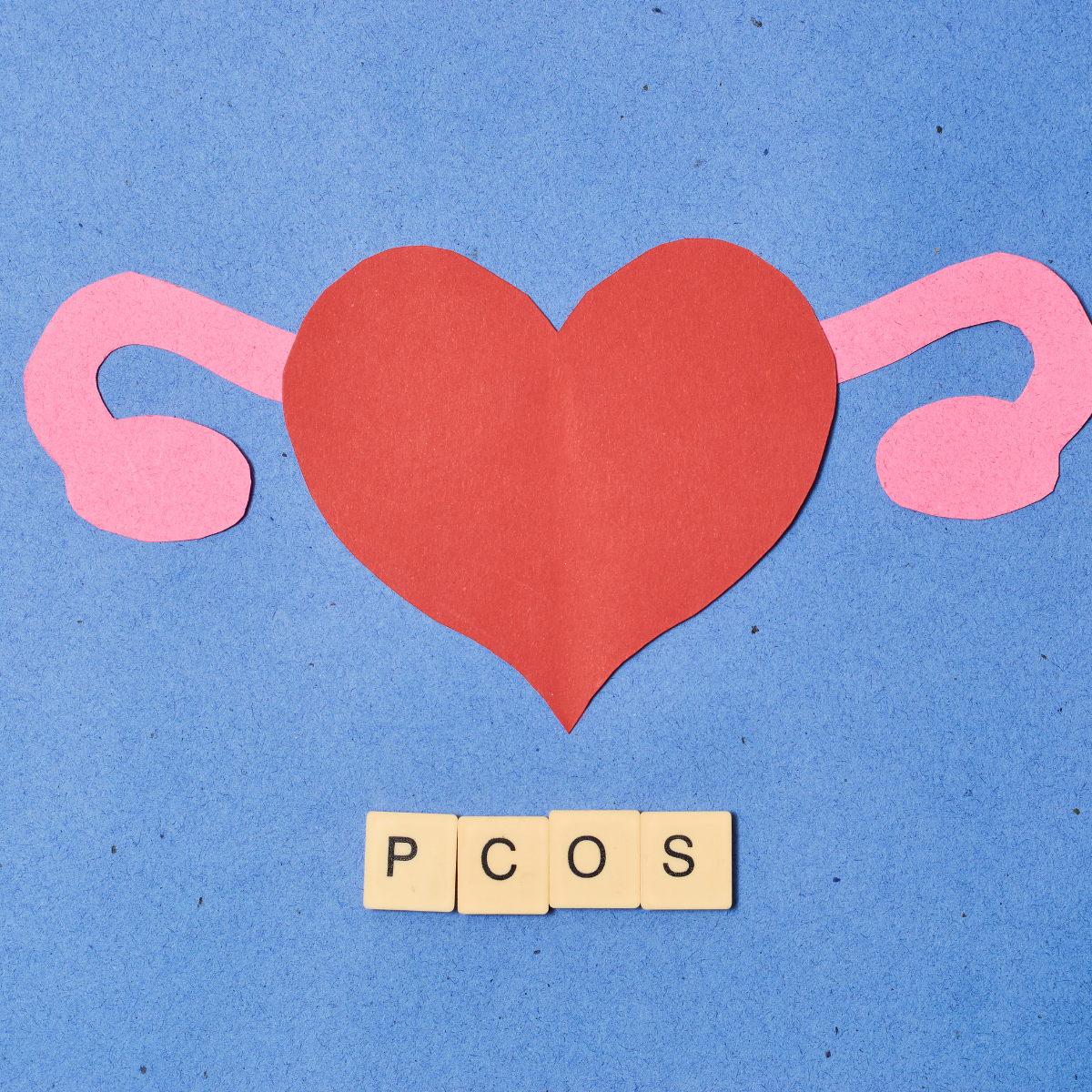 red heart cut out with pink cut outs as ovaries and scramble writing in PCOS