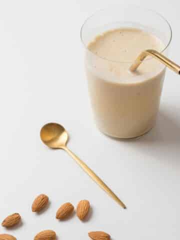 Protein shake on table with spoon and almonds