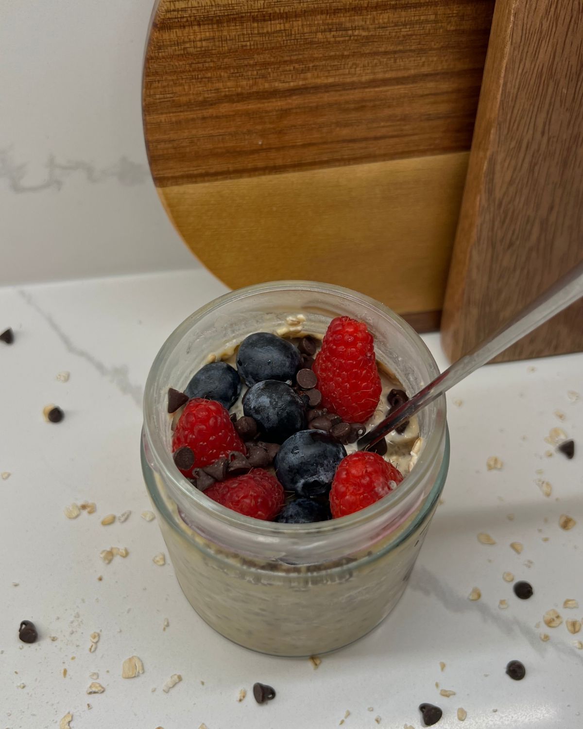 protein oats in mason jar with berries and mini chocolate chips on top