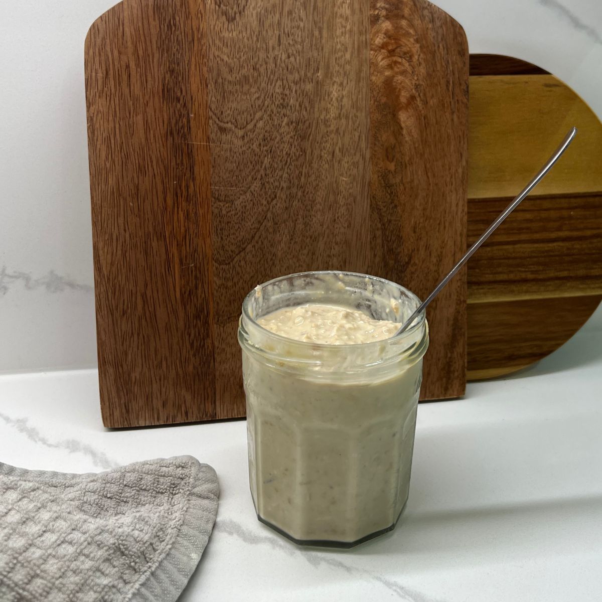 mason jar with spoon in it in front of cutting boards